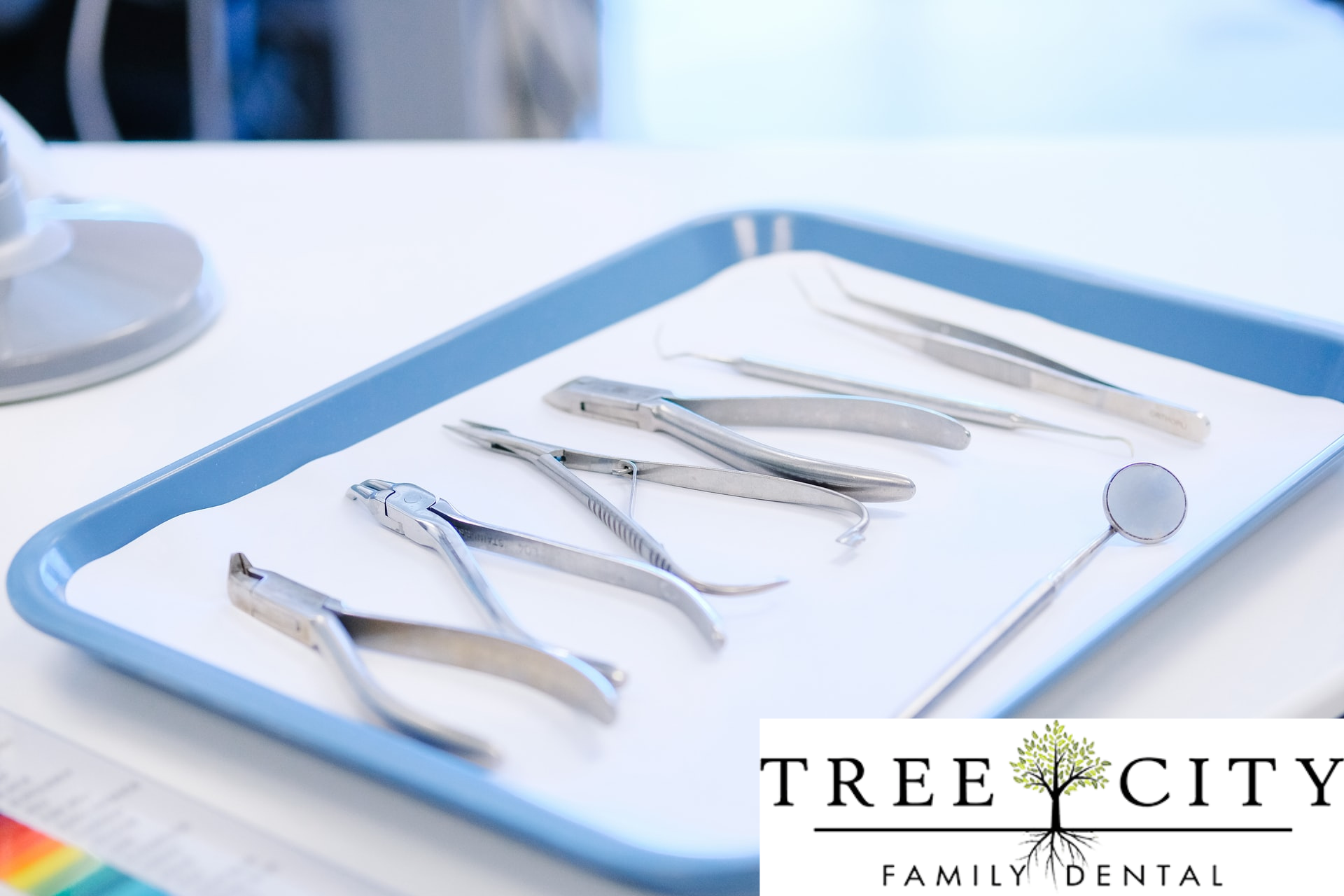A blue tray carrying various dental instruments.